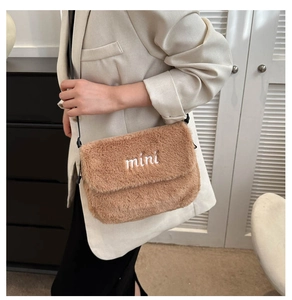 Détail du sac bandoulière en peluche marron avec broderie mini blanche sur tissu doux
