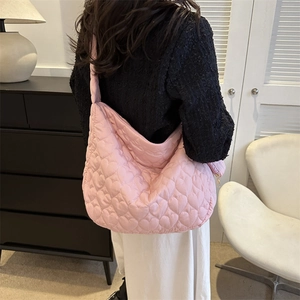 Detail showing pink heart-quilted puffer tote bag with spacious design and wide strap