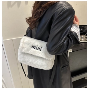 Gros plan sur le sac bandoulière en peluche blanche avec broderie mini contrastée
