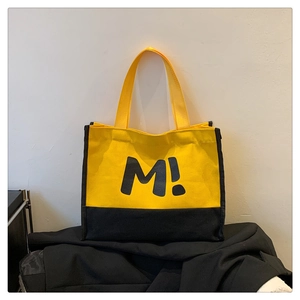 Détail du sac cabas en toile jaune avec imprimé M! noir et anses résistantes