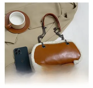 Detail view of brown PU leather crossbody bag with white faux fur trim and chain strap