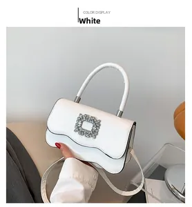Détail du rabat ondulé blanc élégant avec une boucle carrée ornée de strass brillants