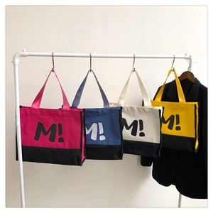 Détail de grands sacs cabas en toile de couleurs rose, marine, blanc et jaune vif