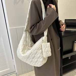 Detail of white heart quilted tote bag with matching mini pouch and metal chain