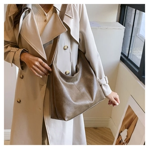 Brown matte leather tote bag detail with wide shoulder strap and vintage texture finish