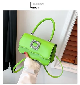 Détail macro du sac en cuir vert fluo avec boucle en cristal étincelante et poignée