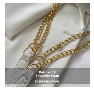 Detail of white crocodile texture leather strap with golden metal chain and rings