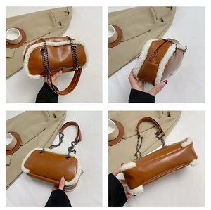 Detail view of brown leather shoulder bag with white faux fur trim and metal chain strap