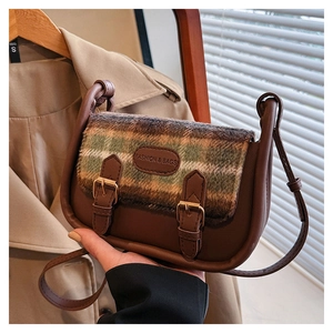 Detail der Vintage-Umhängetasche mit Karo-Muster, Lederklappe und Retro-Schnalle