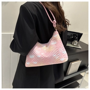 Pink wave-quilted underarm bag with butterfly floral print on a stylish female model