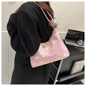 Detail of pink quilted shoulder bag featuring V-shaped knit and delicate butterfly print
