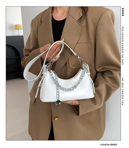 Détail du sac à bandoulière demi-lune blanc avec chaîne en métal argenté et finition cuir lisse