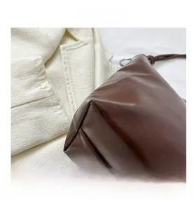 Detailed macro shot of dark brown PU leather tote bag with fine stitching and rounded edges