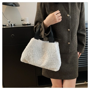 Detail of soft white faux fur tote bag with black contrast handles for winter