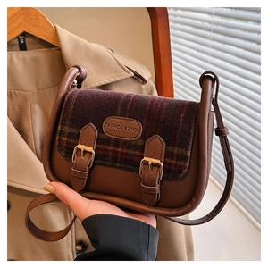 Detail der braunen Retro-Umhängetasche mit Karomuster, Schnallen und Leder-Patch