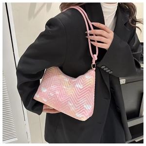 Detail of pink shoulder bag with butterfly patterns and V-shaped quilted texture on model