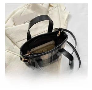 Detail view of plaid woolen tote bag interior showing capacity for wallet and phone