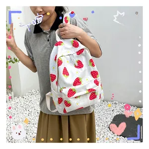Detail of white canvas backpack featuring strawberry and daisy prints and a front zipper pocket