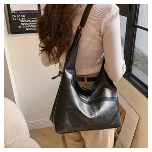 Detail of black large hobo bag with gold adjustable buckle and wide shoulder strap