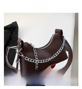 Gros plan du sac croissant marron avec chaîne argentée et large bandoulière