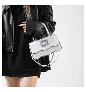 Détail du sac blanc en cuir ondulé avec boucle en cristal et poignée métallique