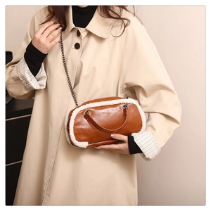 Close-up of winter crossbody bag with brown leather, white faux fur trim and chain strap