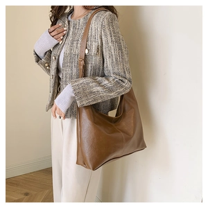 Detail view of large vintage brown tote bag with leather texture and decorative stitching