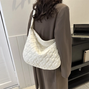 Close-up of white heart-quilted tote bag with premium stitched texture and soft fabric detail