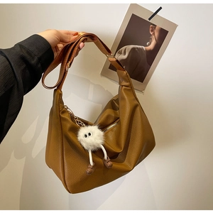Sac hobo en cuir marron avec texture litchi et pendentif en peluche blanche
