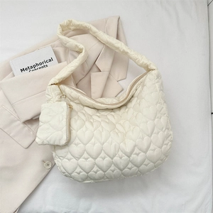 Detail of quilted heart pattern cream tote bag with matching coin purse and soft strap