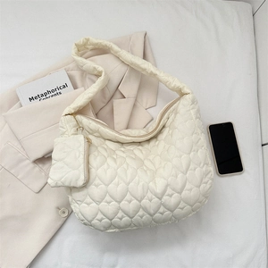 Detail of cream quilted tote bag with heart stitching pattern and matching mini pouch