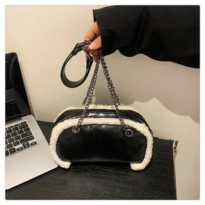 Detail of black faux leather bag with white faux shearling trim and silver chain
