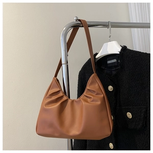 Close-up of caramel pleated cloud shoulder bag with soft PU leather texture details