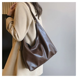 Detail of a dark brown Hobo shoulder bag with top metal zipper and smooth PU leather finish