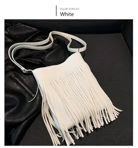 Close-up of white leather crossbody bag with long fringes over a black leather jacket