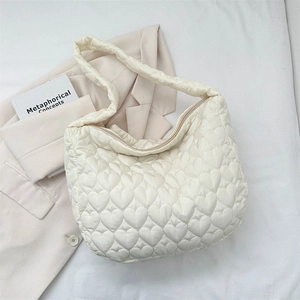 Detail showing the heart-shaped quilted stitching on the lightweight cream tote bag