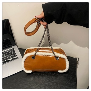 Close-up of caramel leather bag featuring white faux shearling trim and chain strap
