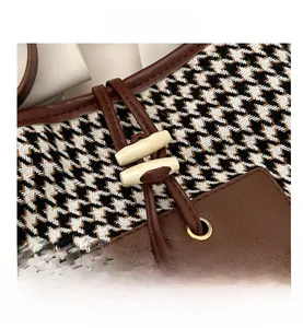 Close-up of houndstooth fabric with brown leather trim and retro wooden toggle closure