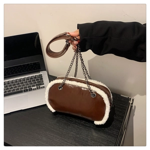 Detailed view of brown leather bag with white faux fur trim and metal chain strap