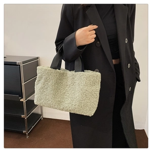 Detail of avocado green faux shearling bucket bag with durable black fabric handles