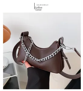 Détail du sac sous l'aisselle marron foncé avec chaîne argentée et cuir lisse