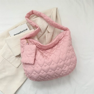 Detail view of pink heart quilted tote with matching mini pouch on white fabric