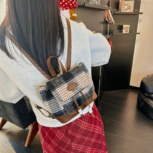 Detailed view of British style houndstooth pattern and leather accents on a backpack