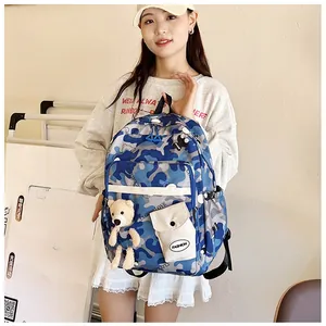 Blue camouflage school backpack with fashion label and cute plush bear accessory