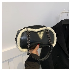 Detail of black faux leather bag with white plush trim and silver chain strap