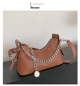 Vue détaillée du sac sous le bras en similicuir marron avec chaîne et pendentif