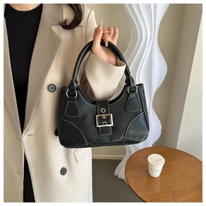Detail of black handbag with contrast white stitching and silver square buckle decor