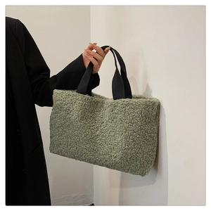 Detail of soft green faux shearling tote bag with contrasting black woven handles