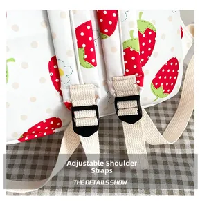 Detail view of adjustable thickened woven shoulder straps with plastic buckles on a strawberry backpack