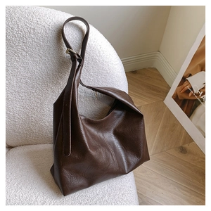 Detail of vintage brown PU leather texture and adjustable strap on large hobo tote bag